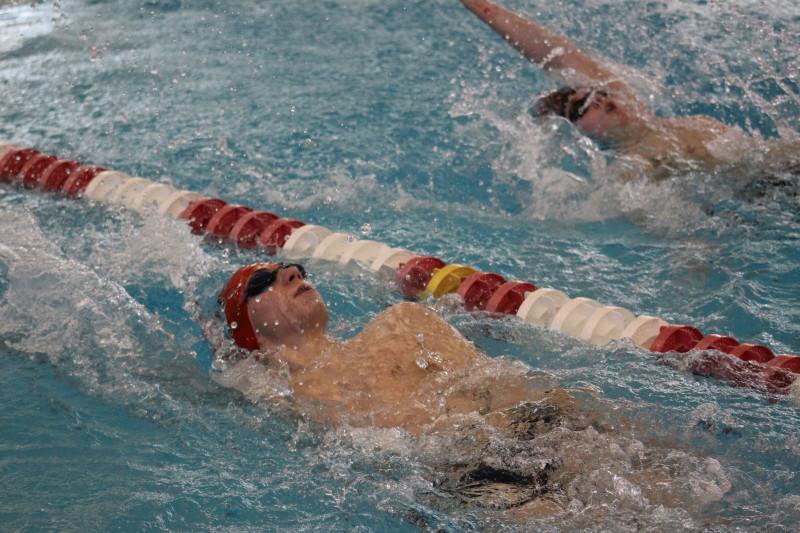 Graham Jolly (10) swims neck-in-neck with St. Francis swimmer Clayton Smedley. Smedley beat Jolly by a single second with a time of 33.04 seconds. Photo by Kate Hatter