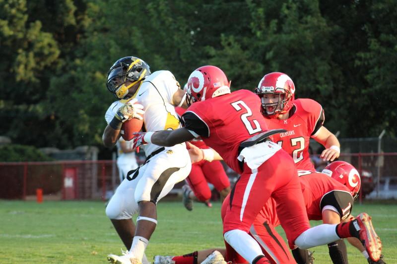 Omari Alexander (12, #2) forces a fumble. The Crimsons forced four turnovers in the game.