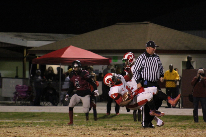 Andre Teague (11, #6) slips down to the ground in order to prevent himself from being tackled. Photo by Kate Hatter 