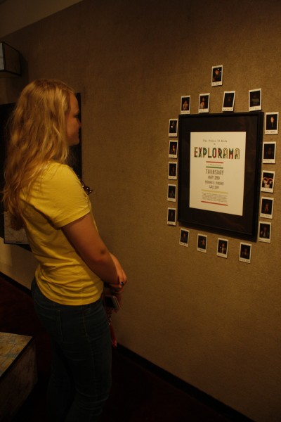 Lauren Fiscus (11) looks at the pictures of the photo 2 students before walking around to see the gallery.
