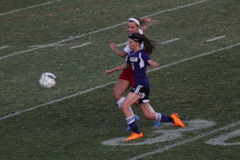 Emma Overstreet (12, #12) blocks a shot from a Male attacker. Photo by Shea Dobson