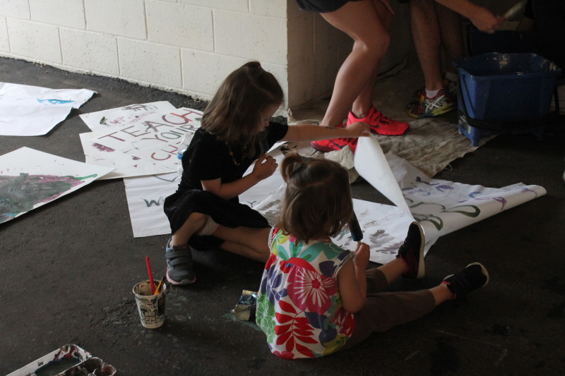 Young community members help paint signs. Event attendees ranged in age from infants to senior citizens. Photo by Kaylee Arnett.