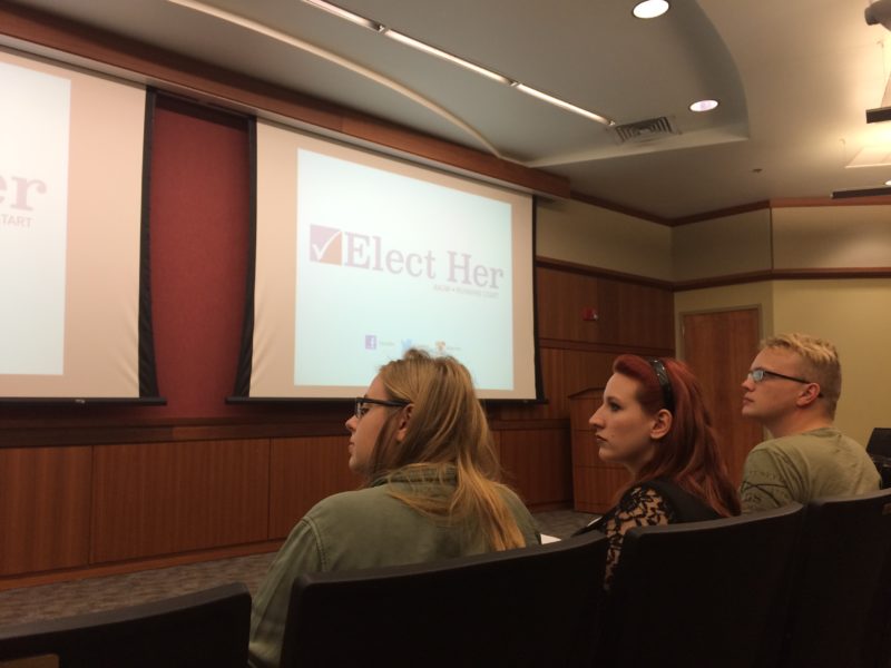 Audience members listen intently to Jessica Kelly present about women in politics.